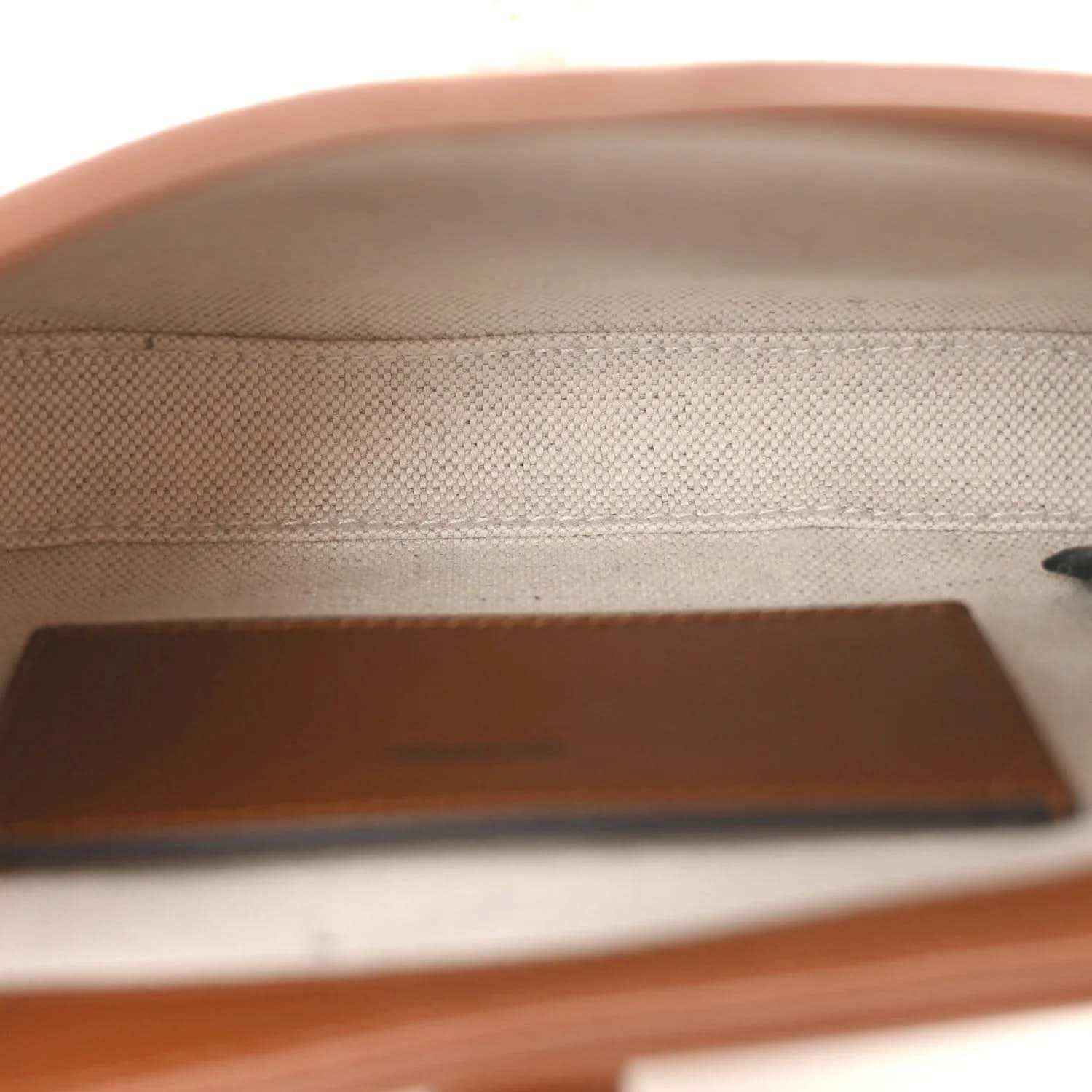 Mini hobo bag interior close-up with beige canvas texture and brown leather trim panel