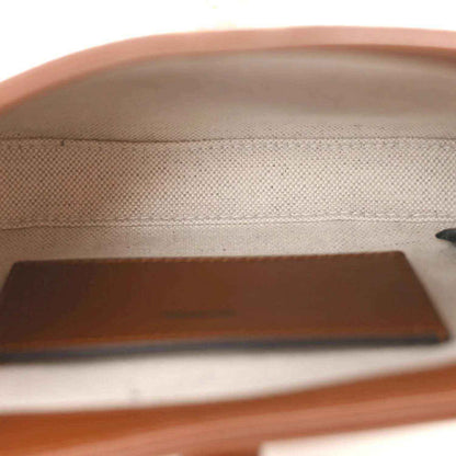 Mini hobo bag interior close-up with beige canvas texture and brown leather trim panel