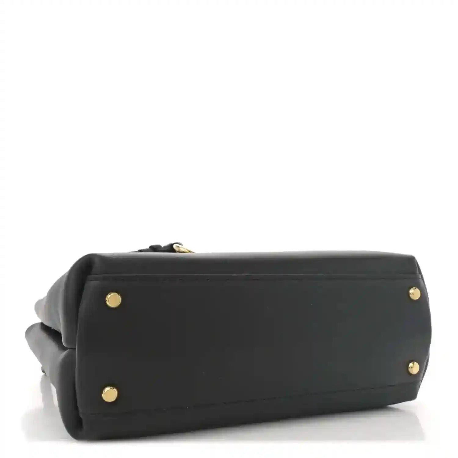Black small shoulder bag with flat base and gold-tone hardware feet.