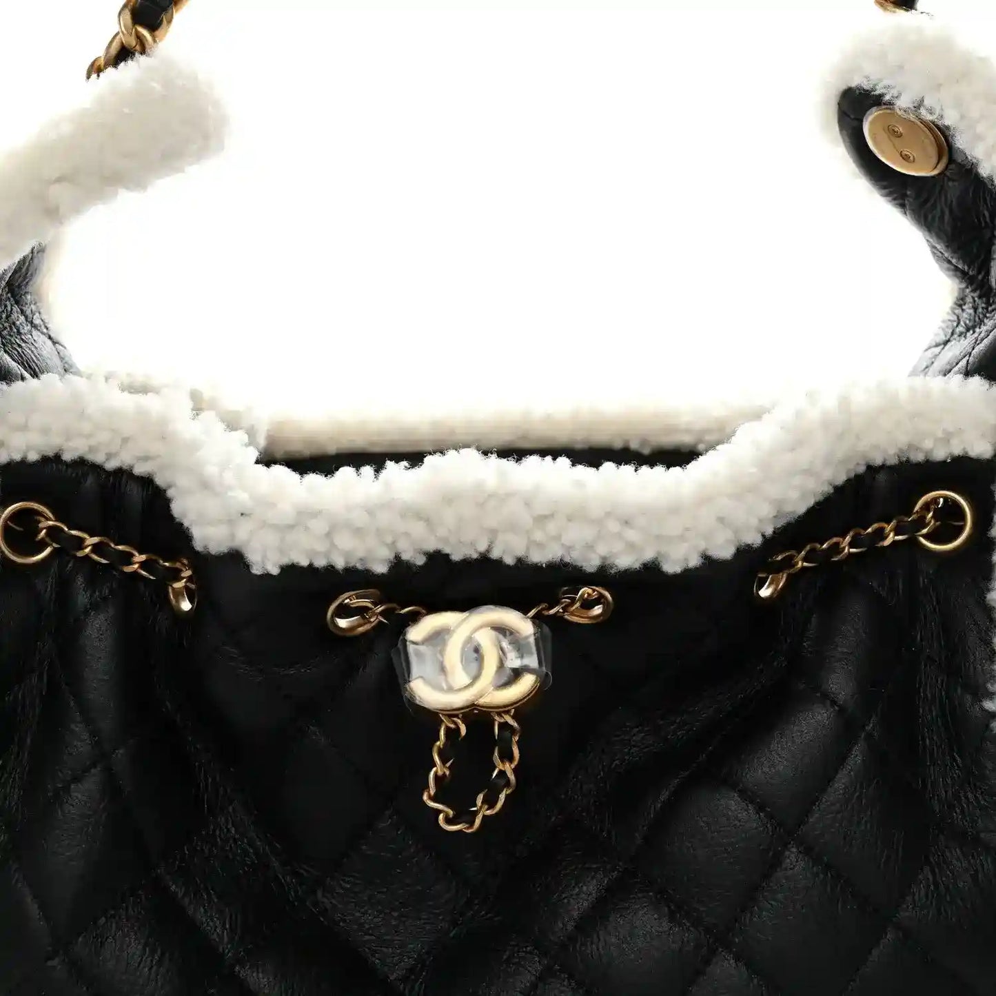 Black quilted handbag with white shearling interior and gold-tone chain strap