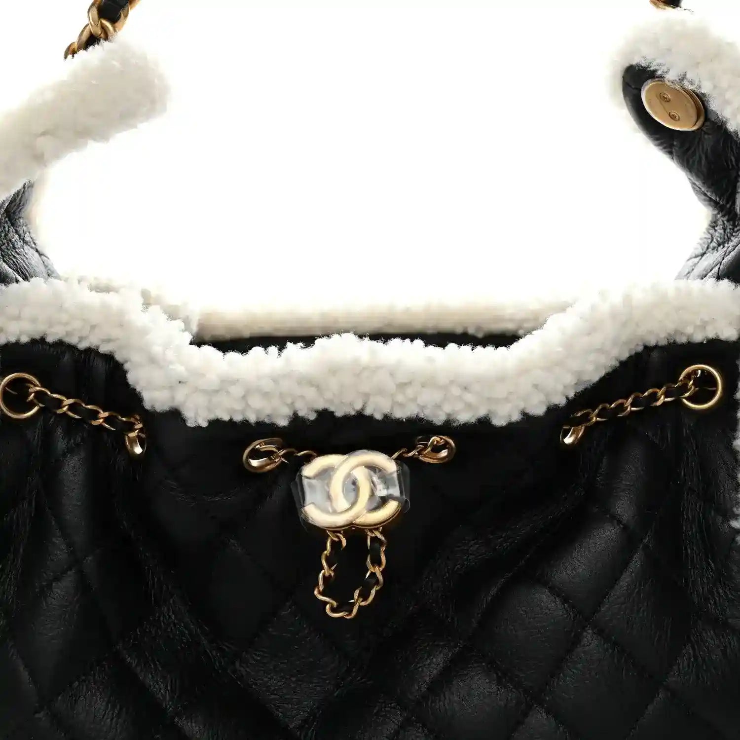 Black quilted handbag with white shearling interior and gold-tone chain strap