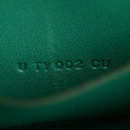 Green leather emboss mark with small printed characters