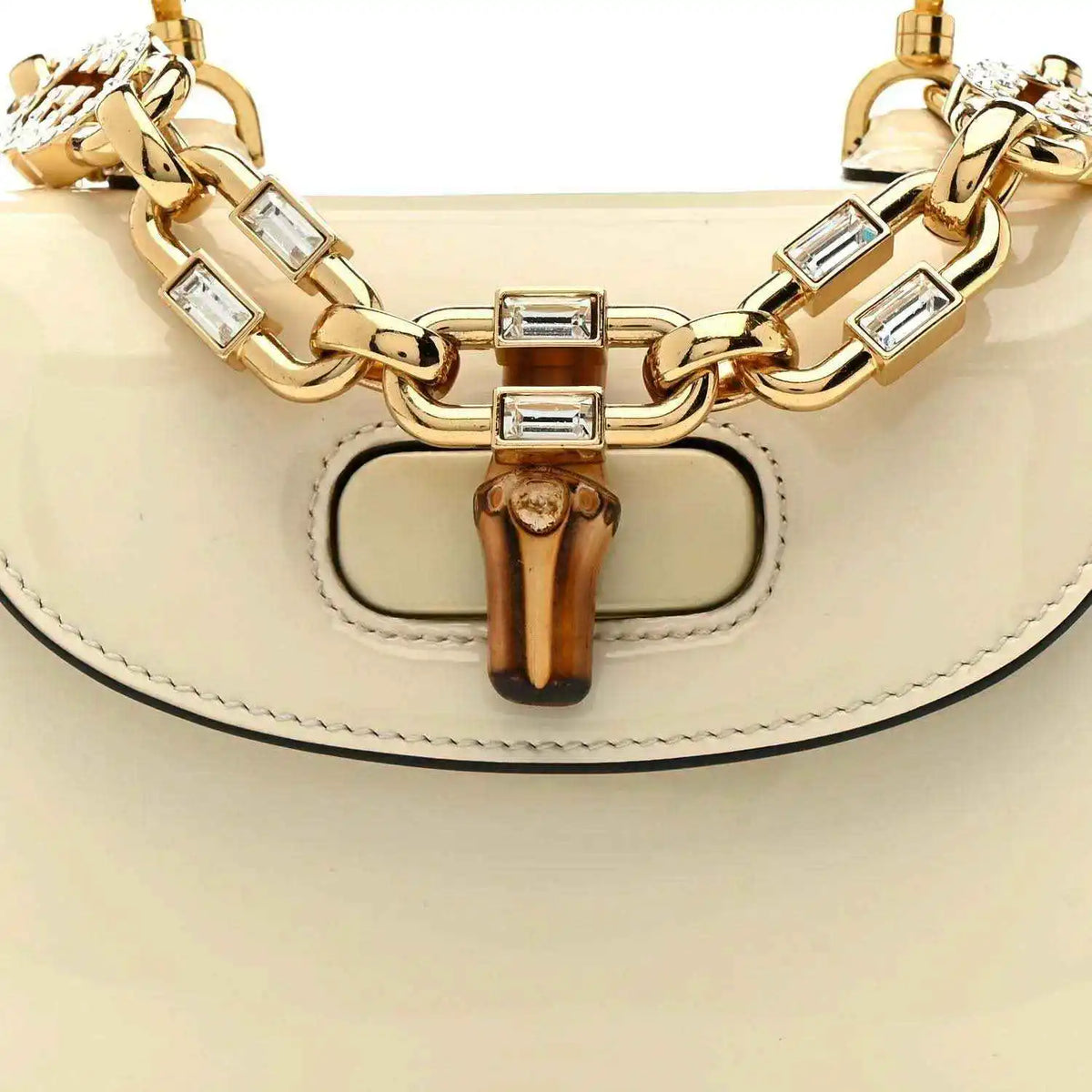 Front of white mini handbag with bamboo clasp, gold chain links, and hinged hardware
