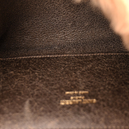 Dark brown leather satchel closeup with small gold logo stamp