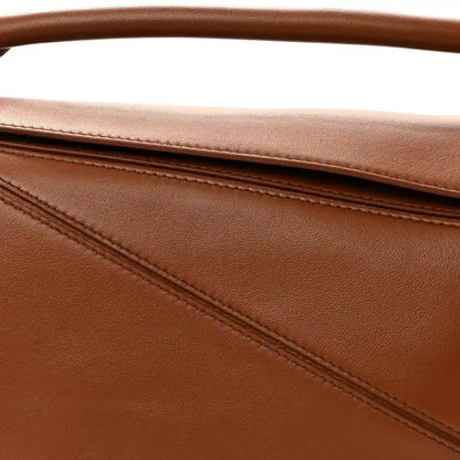 Pecan brown leather bag panel with stitched seam detail and top edge