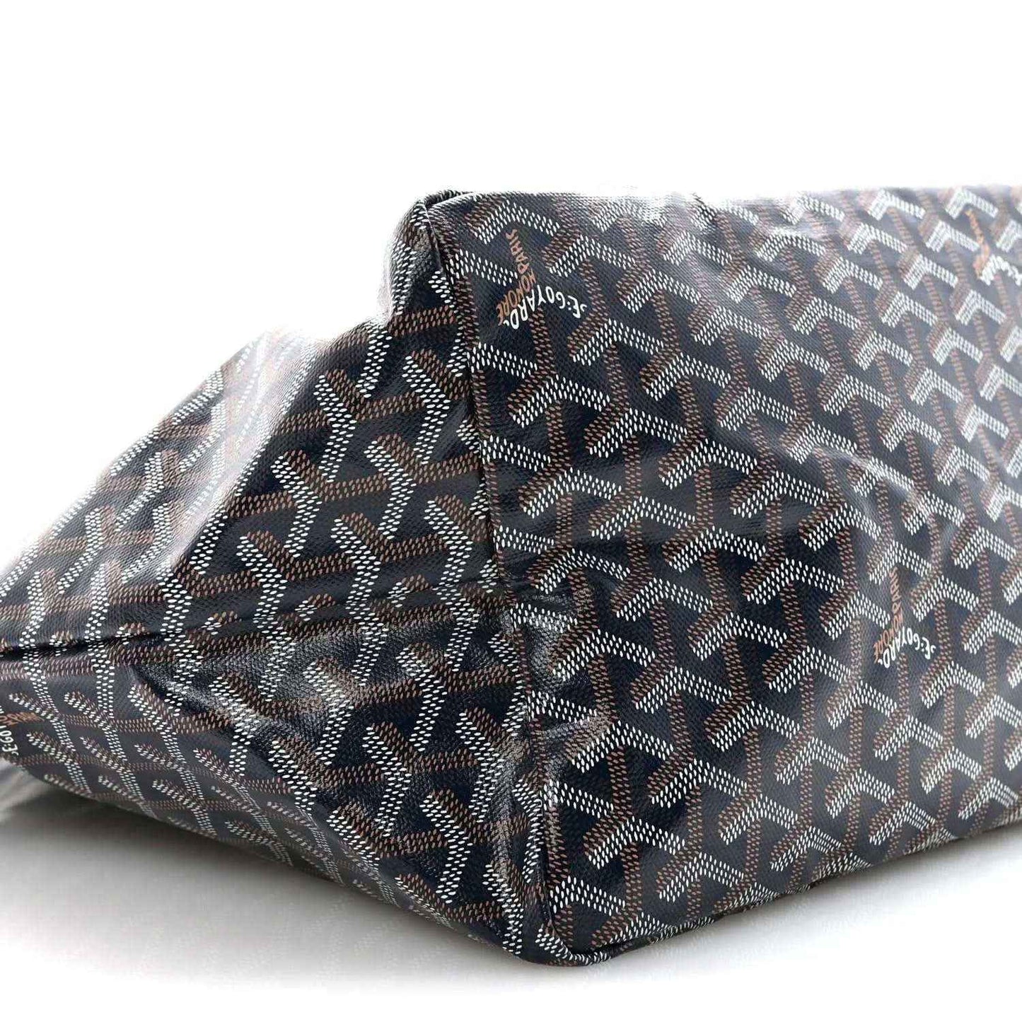 Navy patterned tote bag corner close-up with repeating Goyard logo motif.