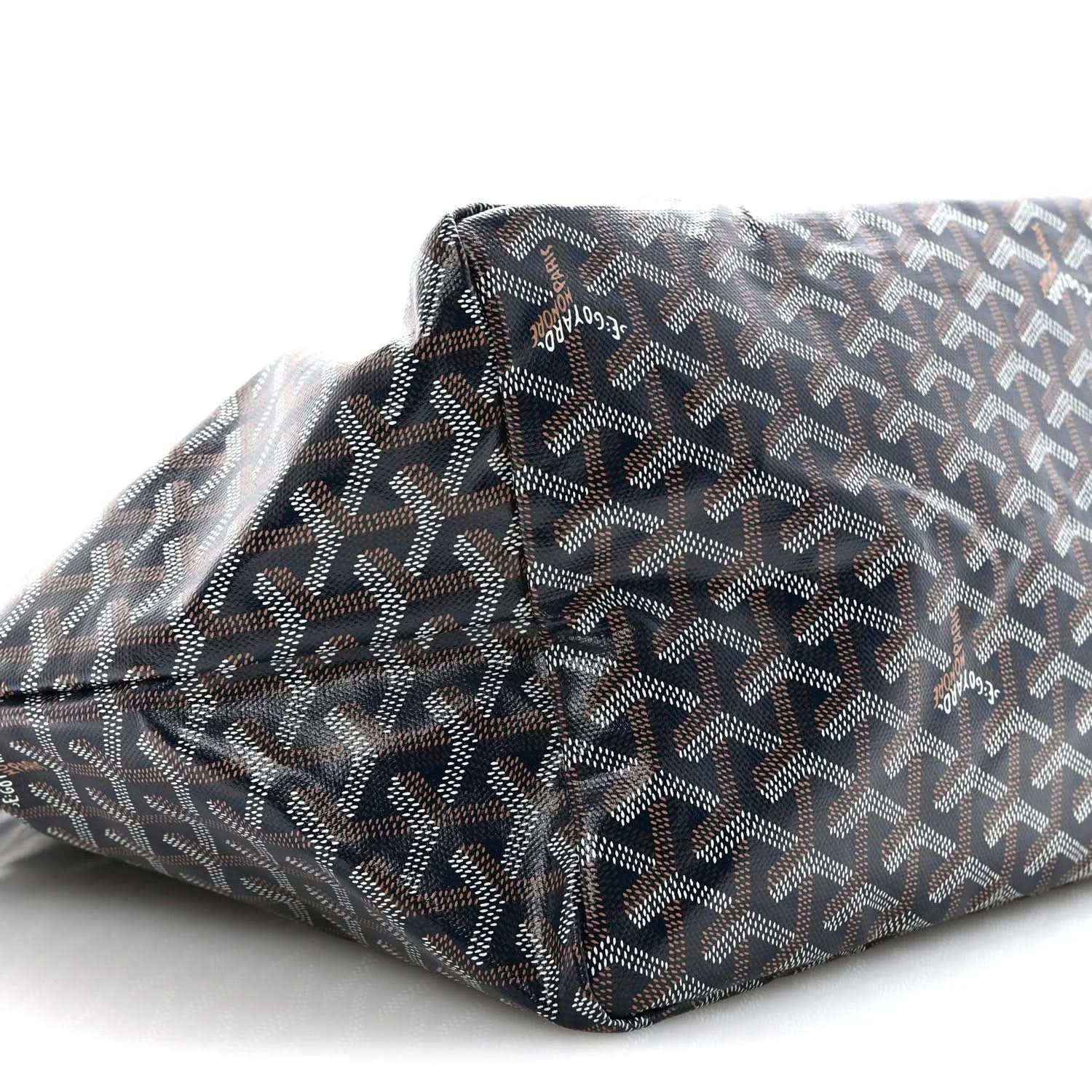 Navy patterned tote bag corner close-up with repeating Goyard logo motif.