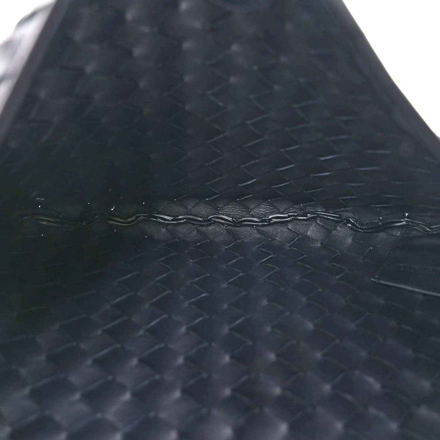 Close-up of dark woven nappa leather texture on the bag