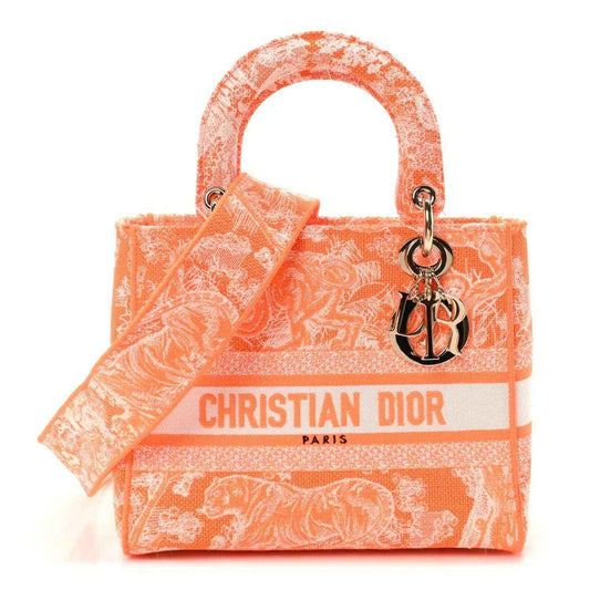 Orange embroidered tote bag with top handles, Dior logo ribbon and charm detail.