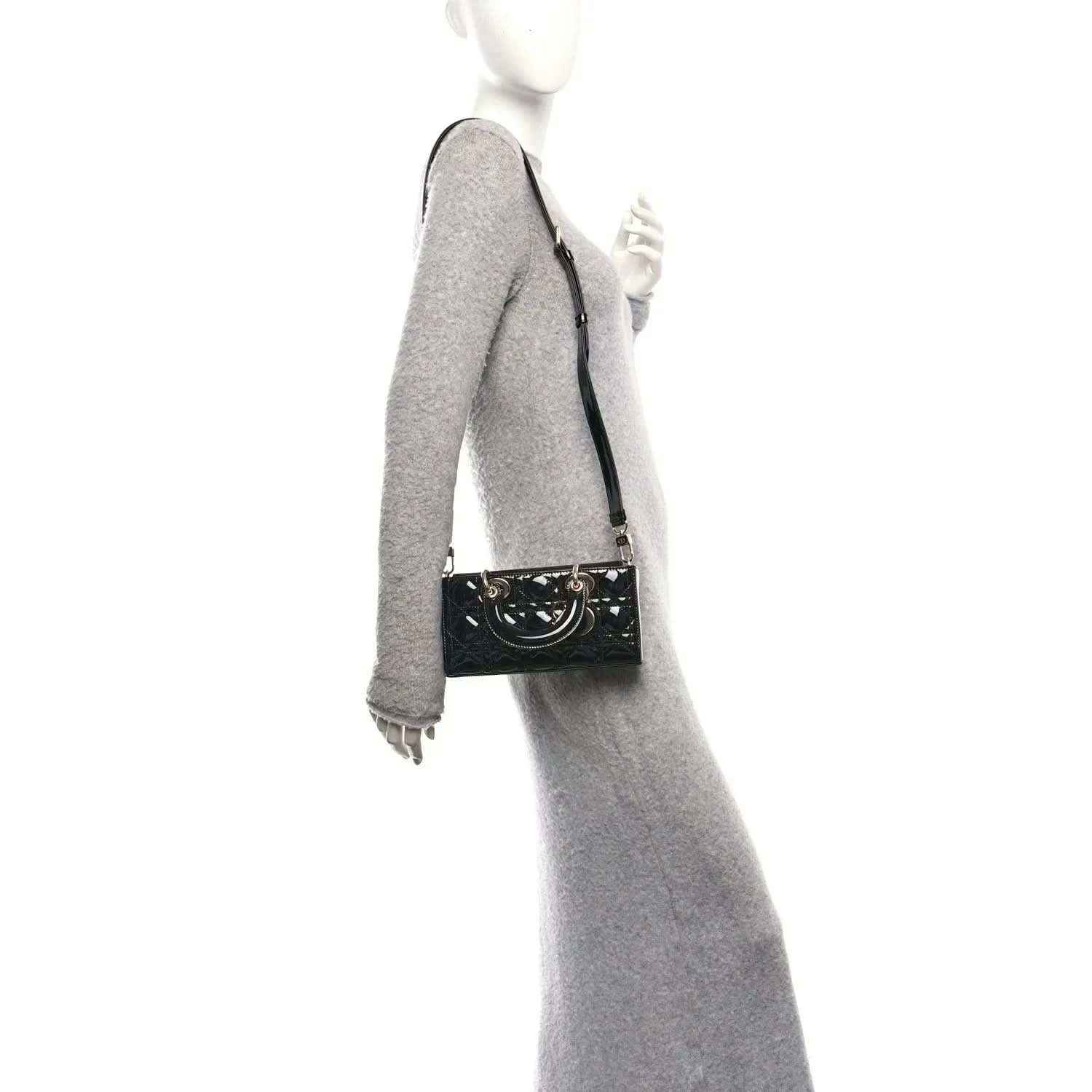 Black patent leather crossbody bag with front logo plaque and adjustable strap