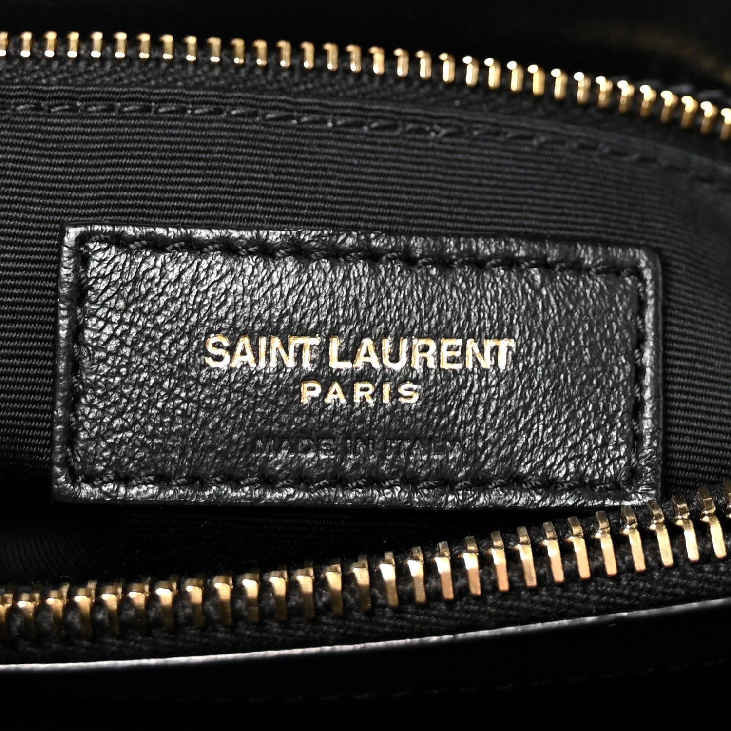 Black leather logo patch with SAINT LAURENT PARIS text and gold zipper