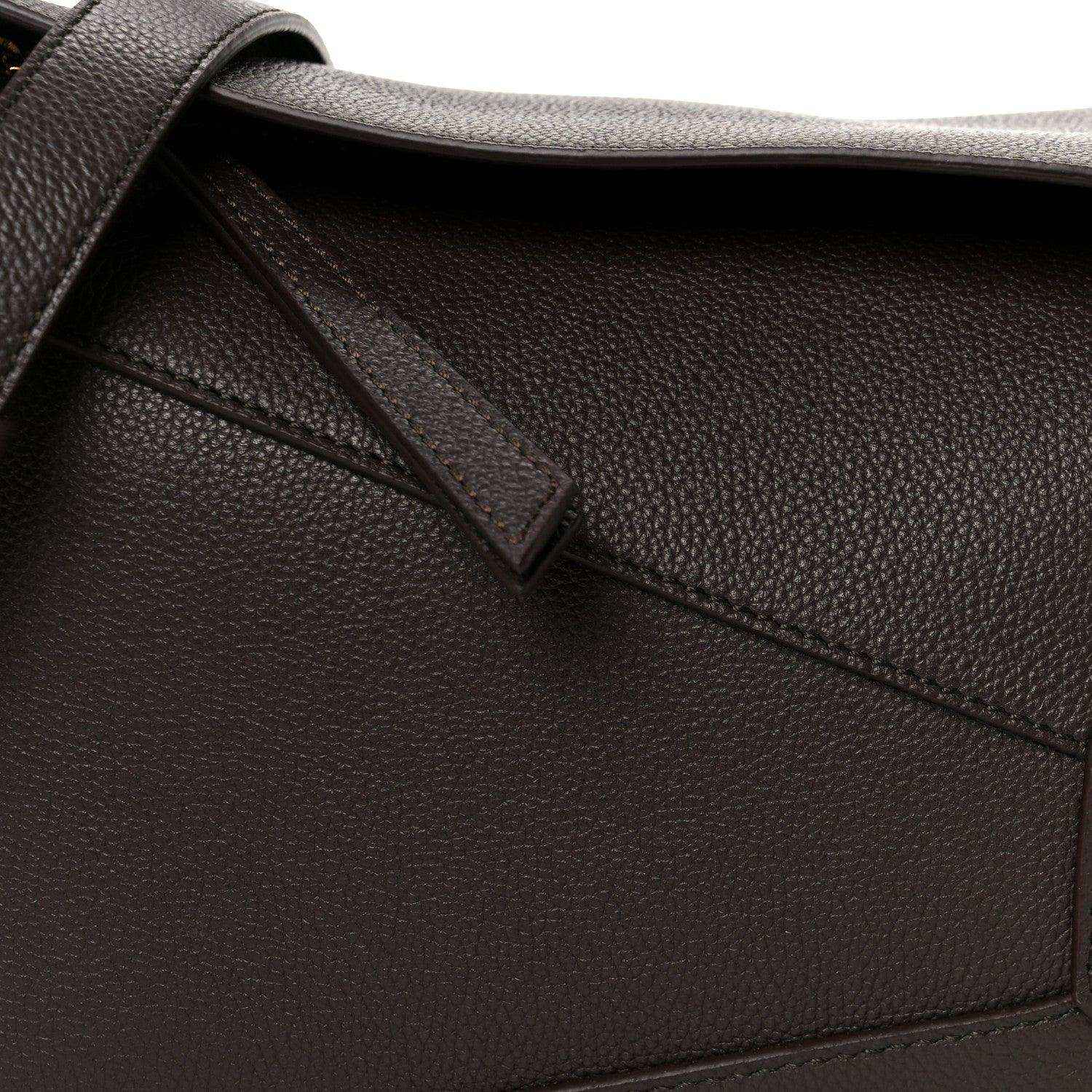 Dark chestnut grained leather strap attachment and diagonal panel seam detail