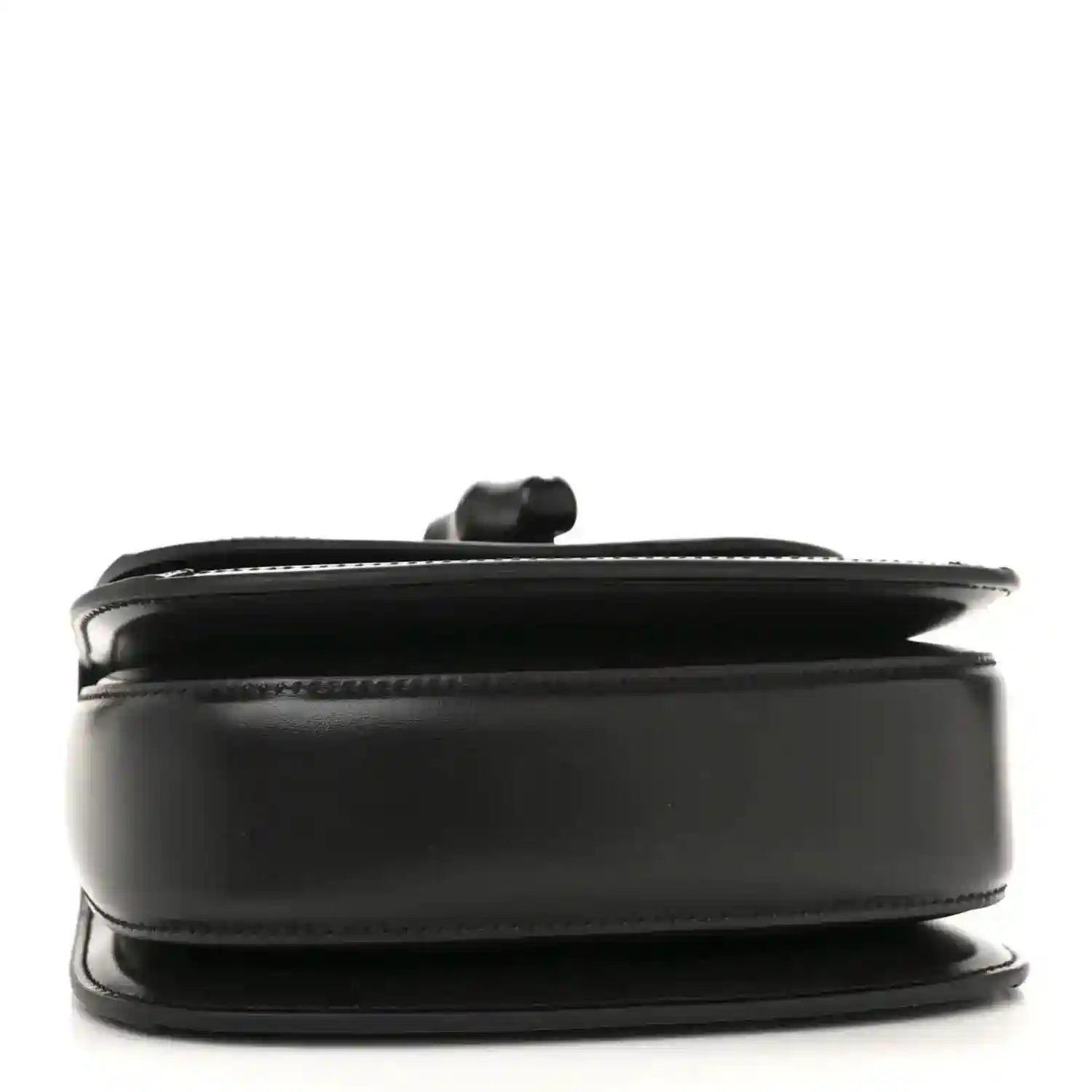 Black mini handbag side profile with curved top handle and smooth trim.