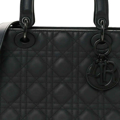 Black quilted Lady Dior bag with top handles, rings, and hanging charm