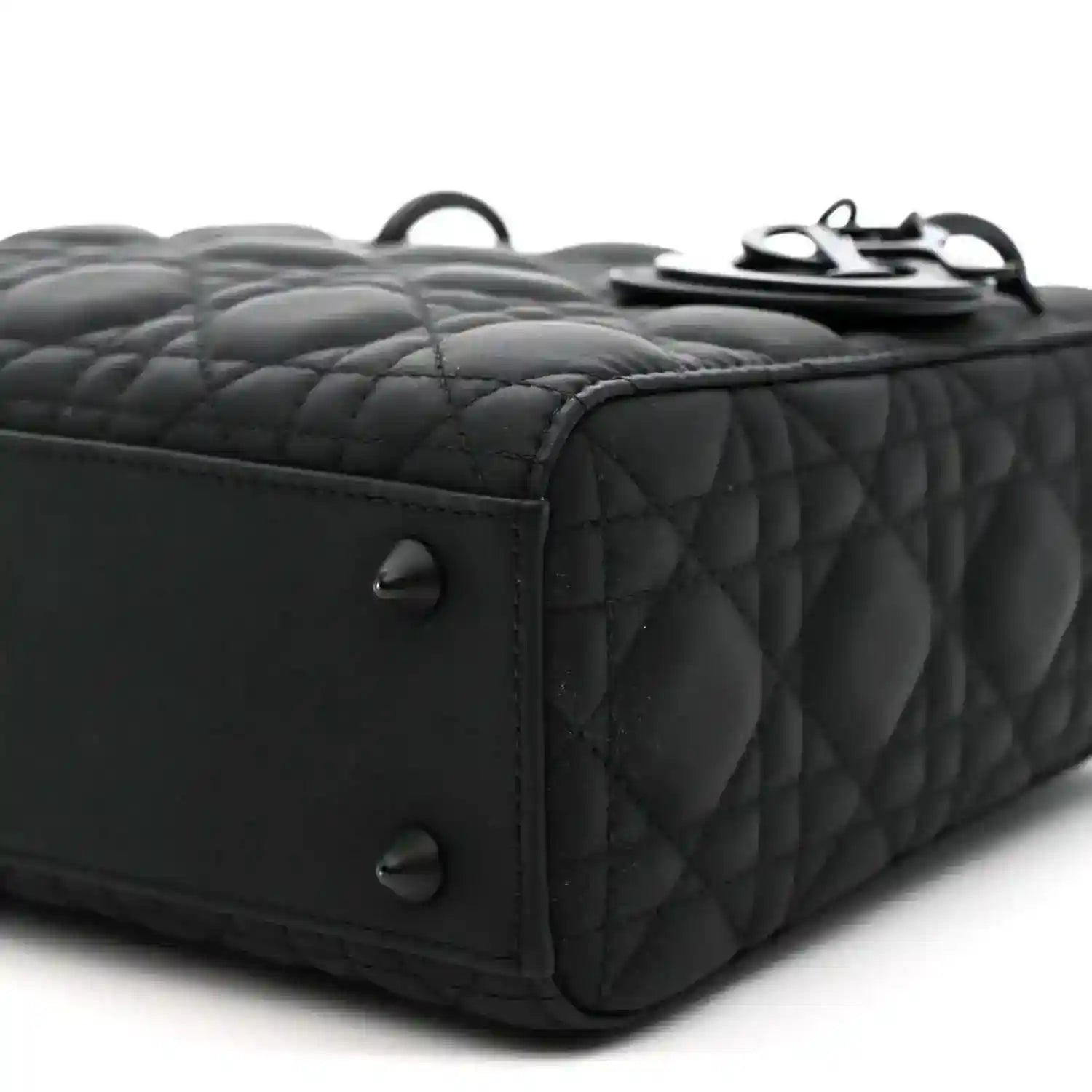Black quilted handbag side corner with two feet and edge stitching