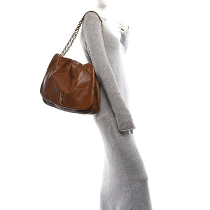 Tan-brown leather small shoulder bag with short chain strap, curved flap.