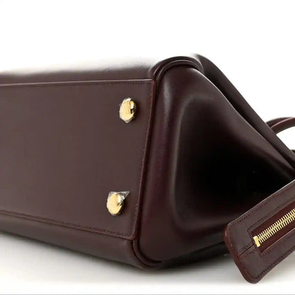 Loewe Small Madrid bag corner close-up in dark burgundy calfskin with strap and zipper