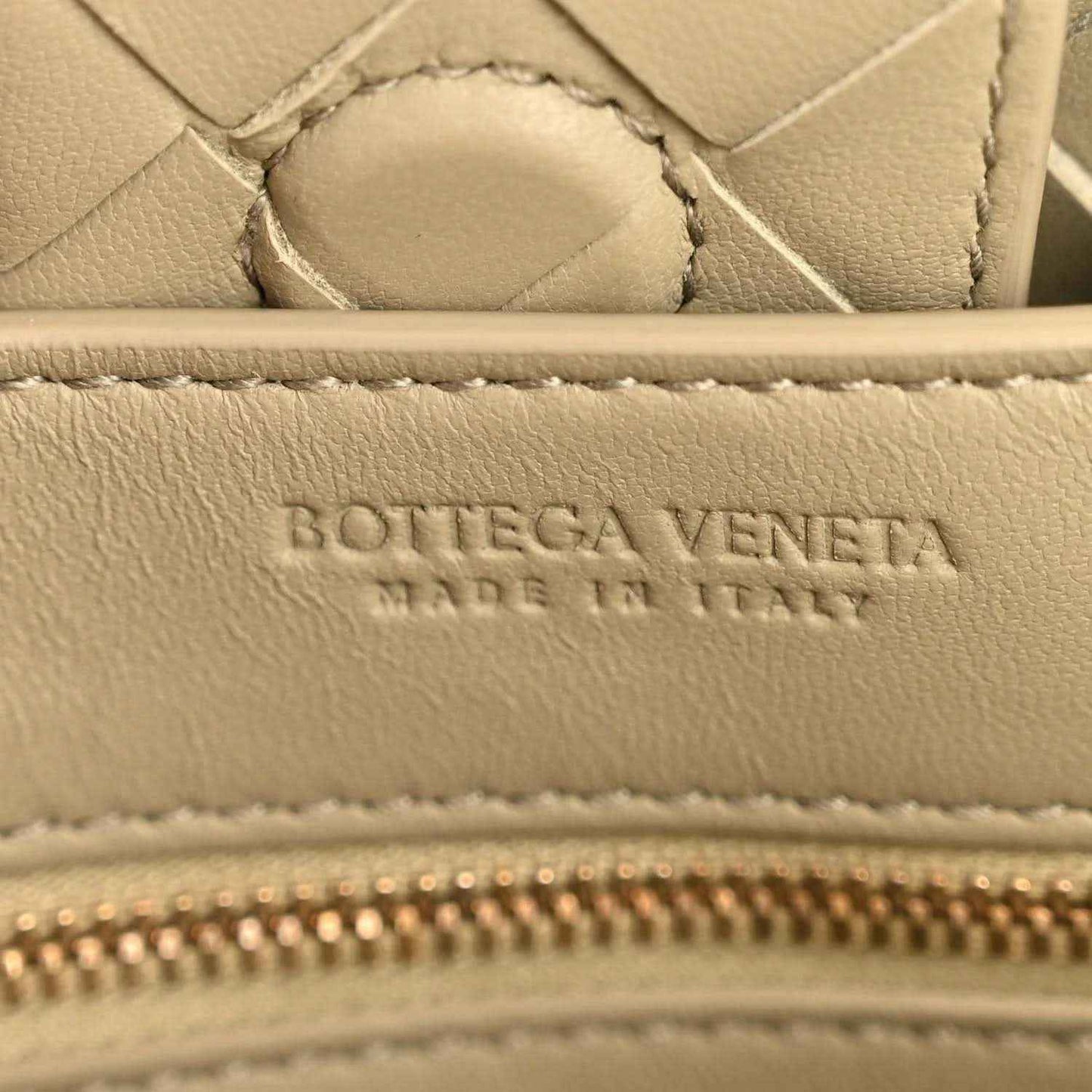 Bottega Veneta logo and zipper detail on travertine-tone leather interior