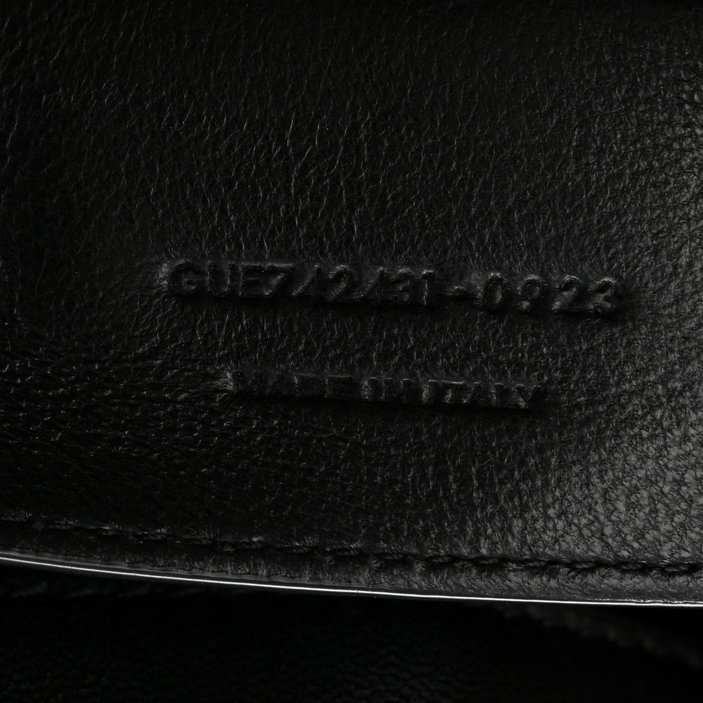 Black leather bag close-up of embossed serial code and stitching line