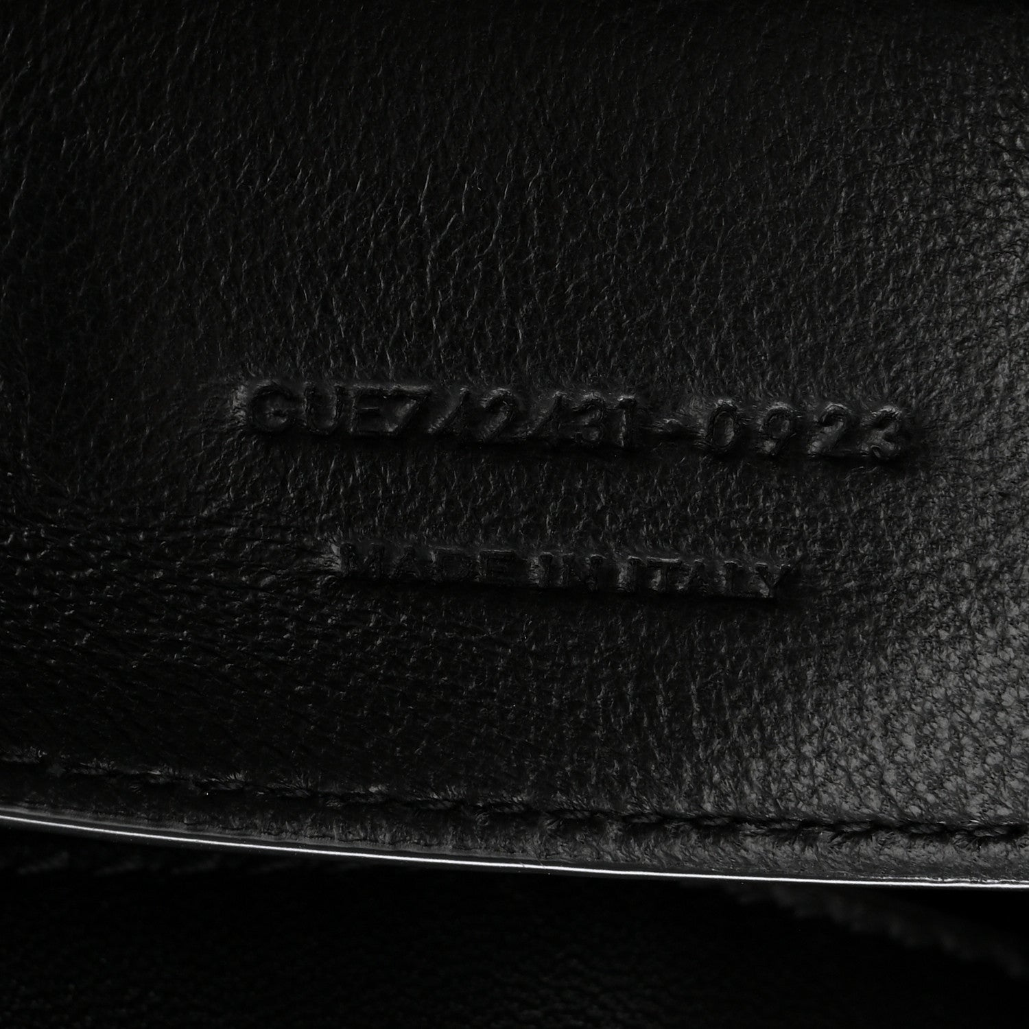 Black leather bag close-up of embossed serial code and stitching line