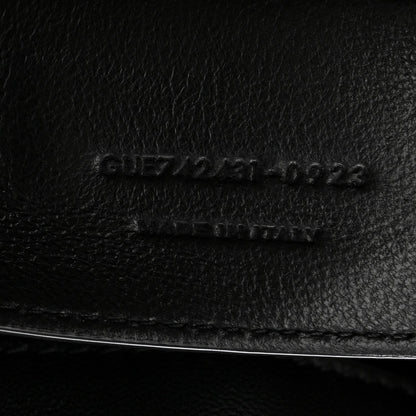 Black leather bag close-up of embossed serial code and stitching line
