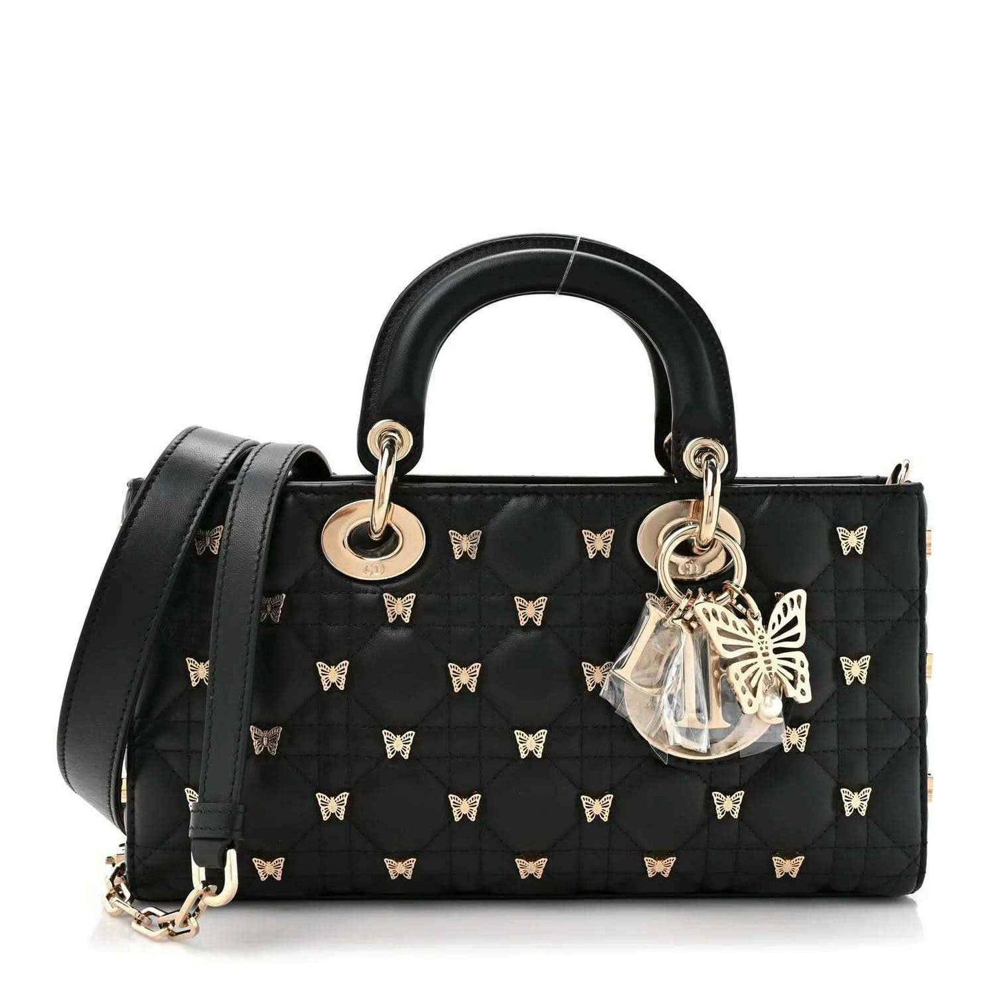 Black quilted top handle bag with butterfly motifs, gold rings, and detachable shoulder strap