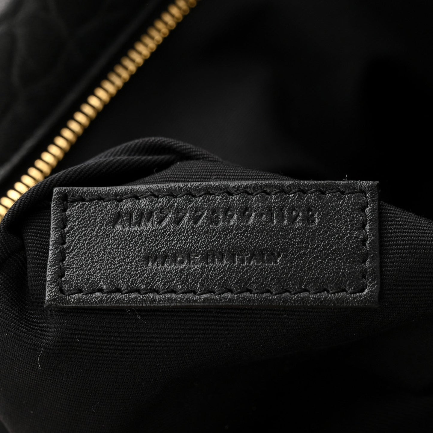 Saint Laurent bag interior leather label on black lining near gold zipper