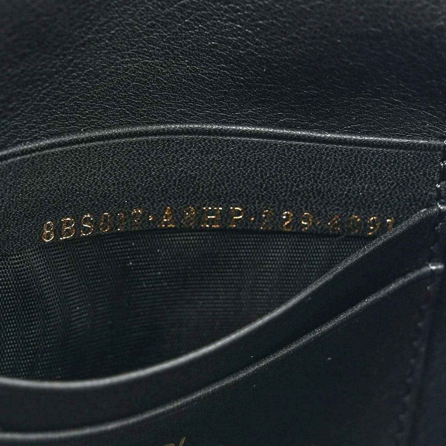 Black leather lining with embossed text, close-up on mini baguette bag.