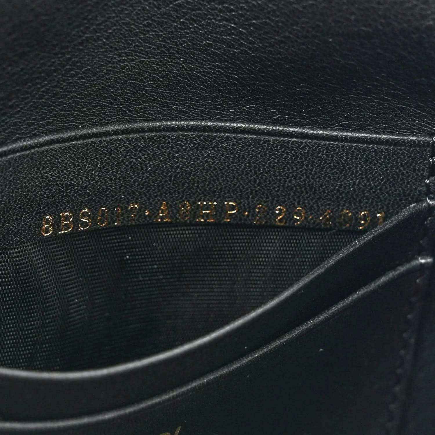 Black leather lining with embossed text, close-up on mini baguette bag.
