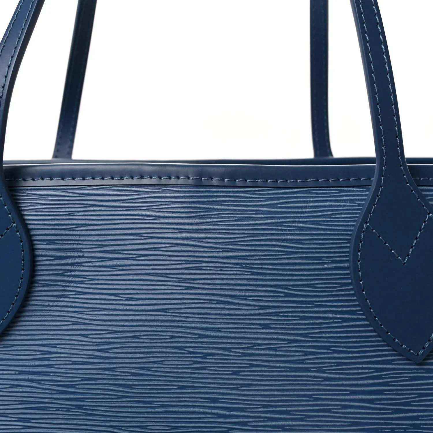 Denim blue leather tote bag close-up of top edge with stitched handle attachment