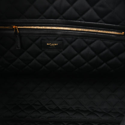 Saint Laurent ES quilted travel bag interior, gold zipper track and black quilted lining.