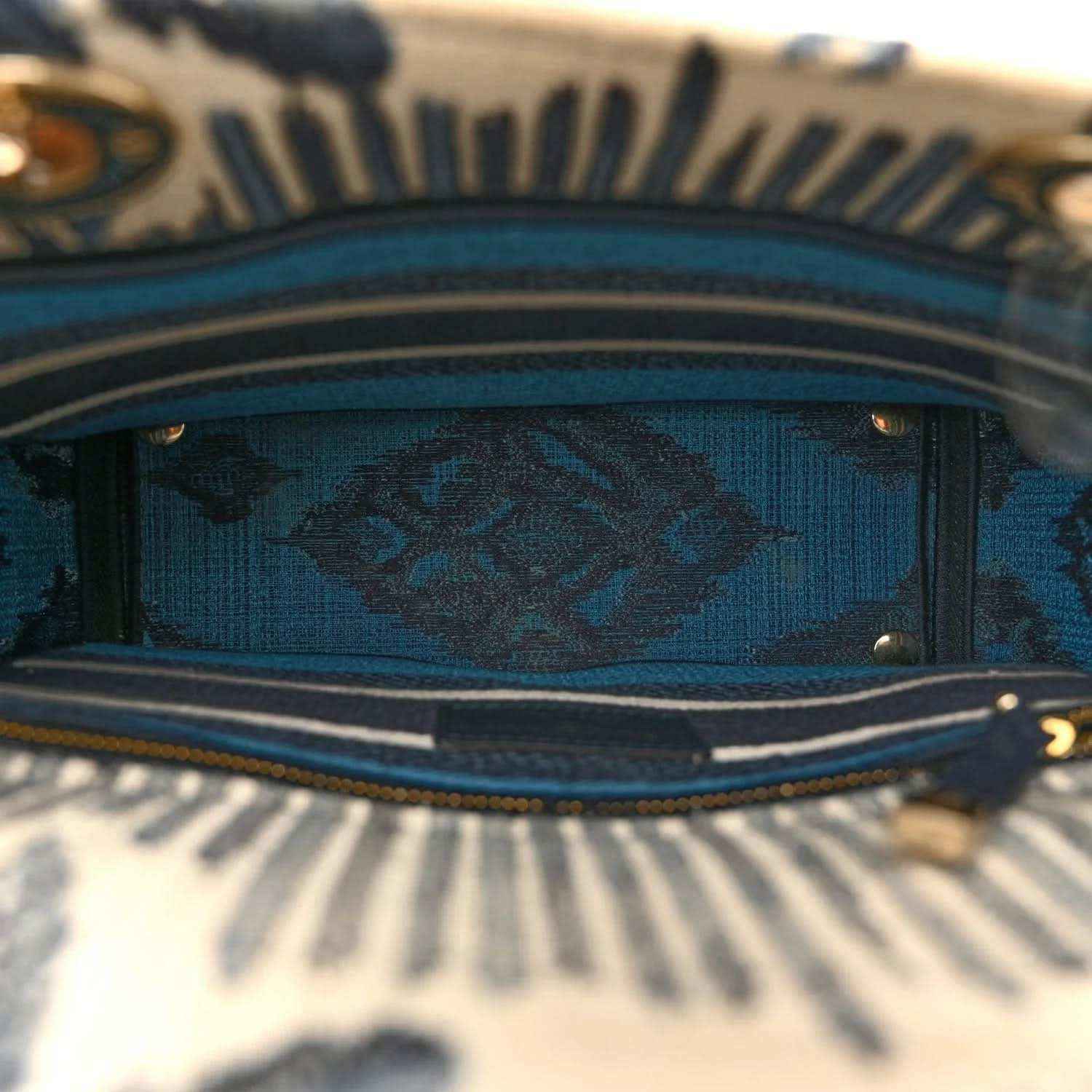Bag top opening with blue patterned lining and navy trim along the edge