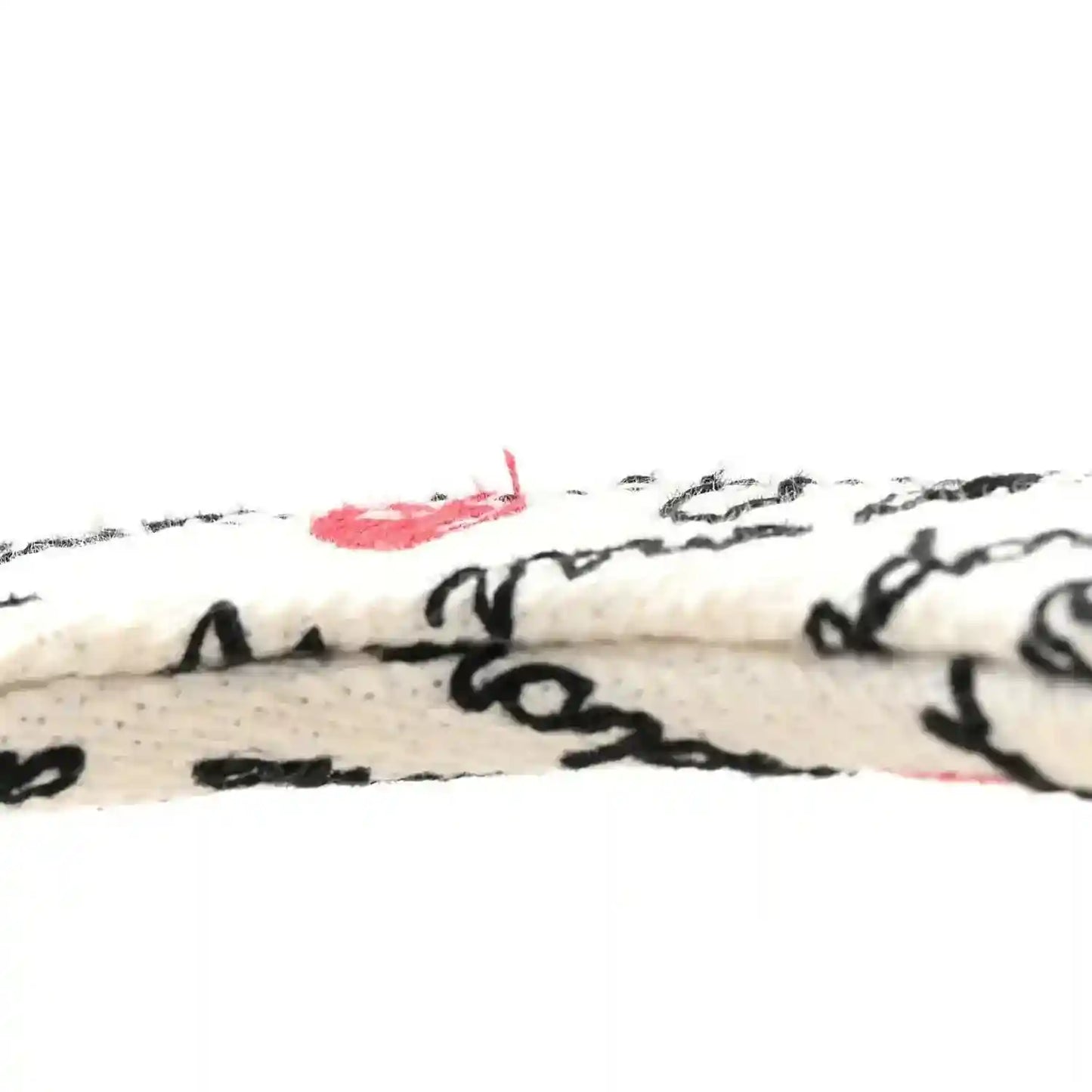 Embroidered canvas handbag panel with black script and small red accents