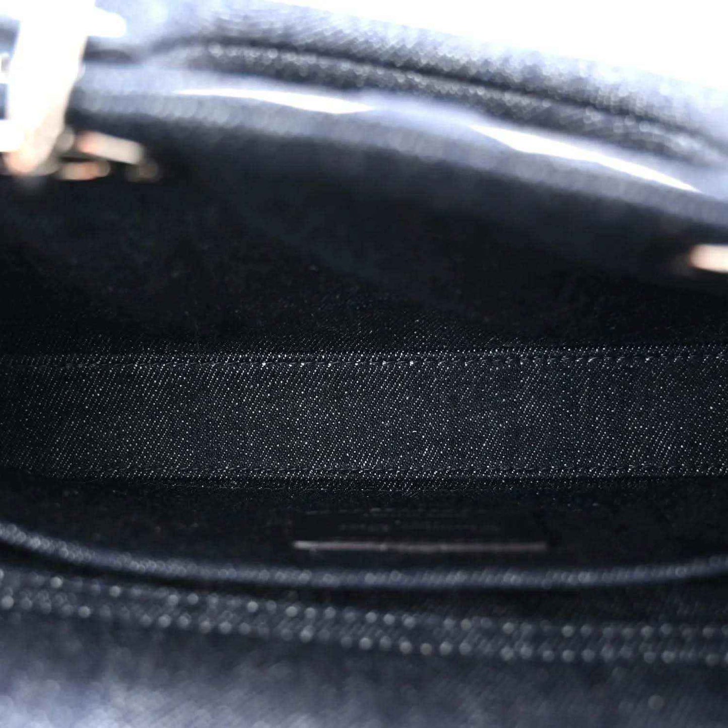 Dark blue denim handbag fabric close-up with stitched seam and eyelet dot pattern