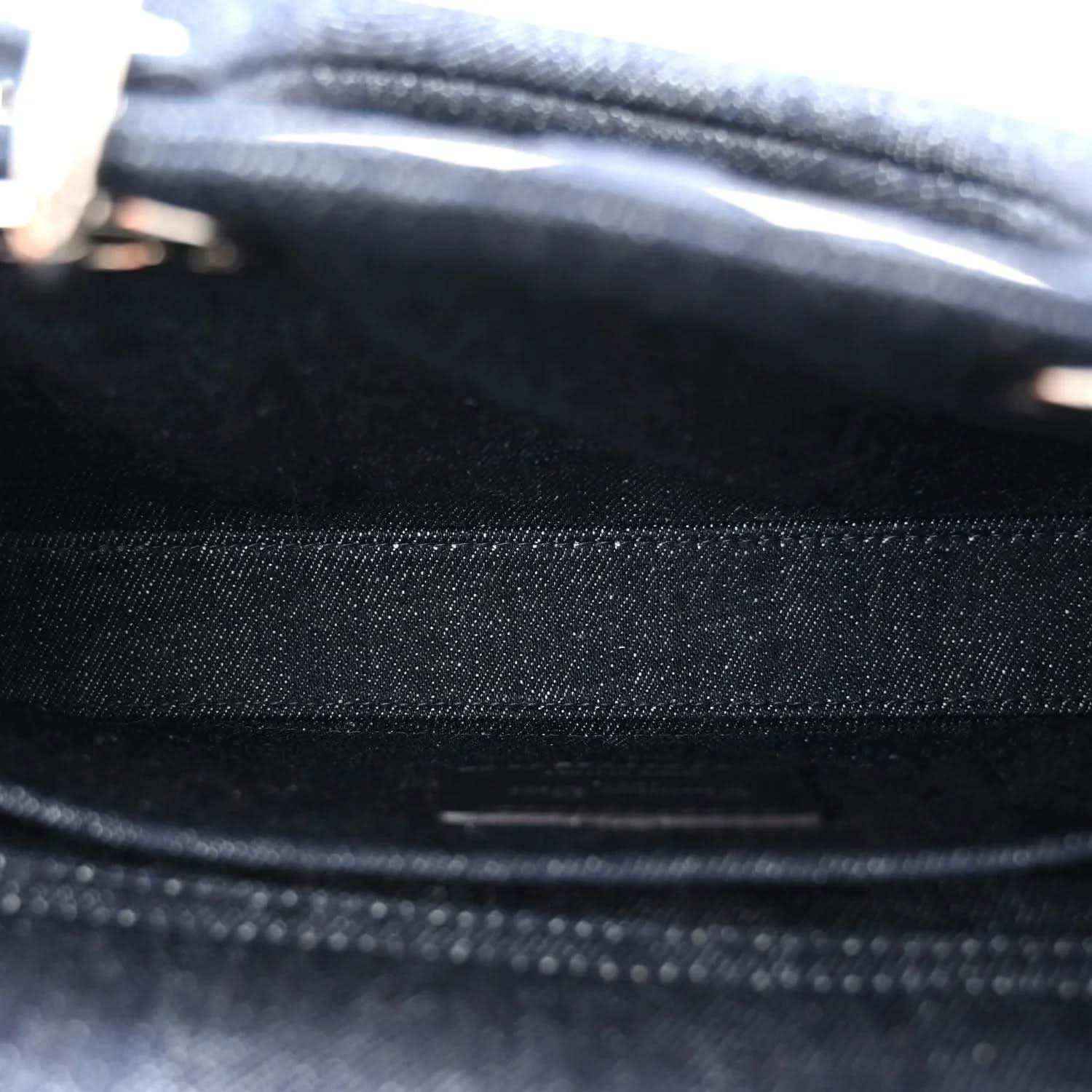 Dark blue denim handbag fabric close-up with stitched seam and eyelet dot pattern