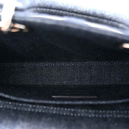 Dark blue denim handbag fabric close-up with stitched seam and eyelet dot pattern