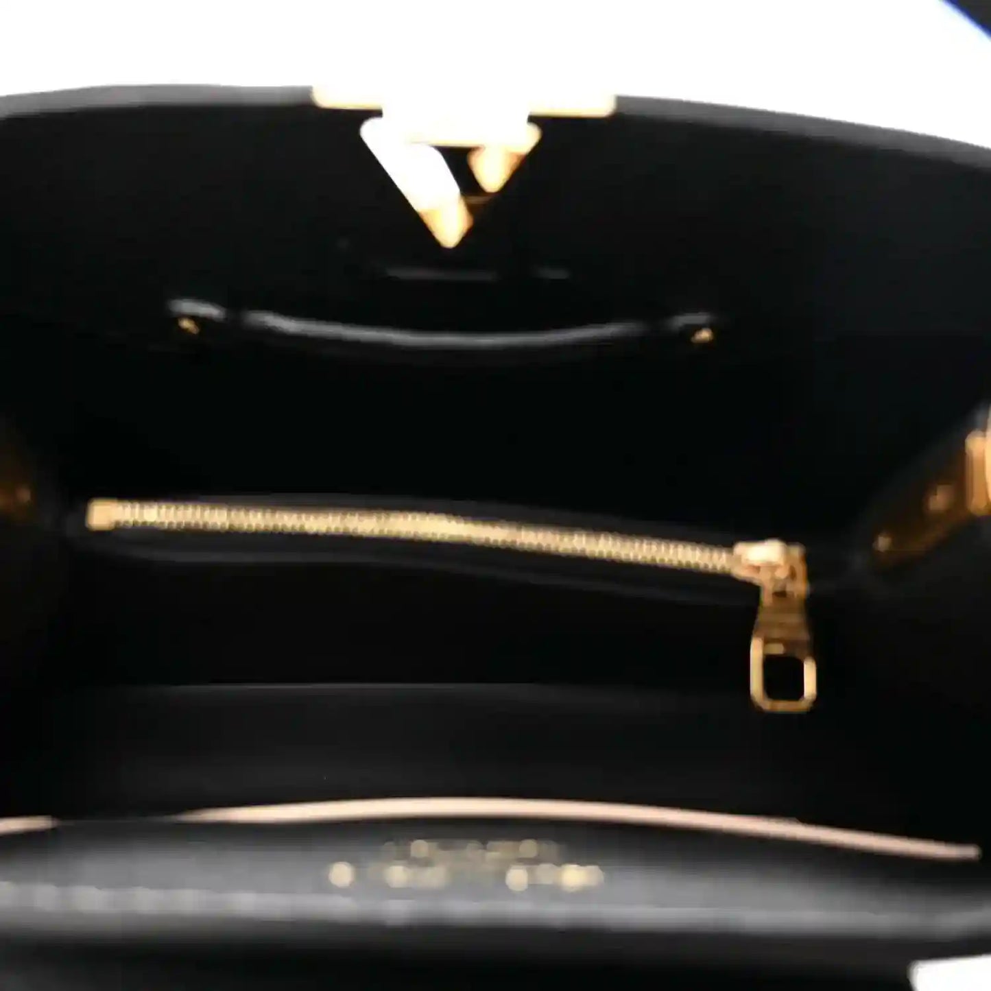 Black leather handbag interior with gold-tone zipper and hardware detail