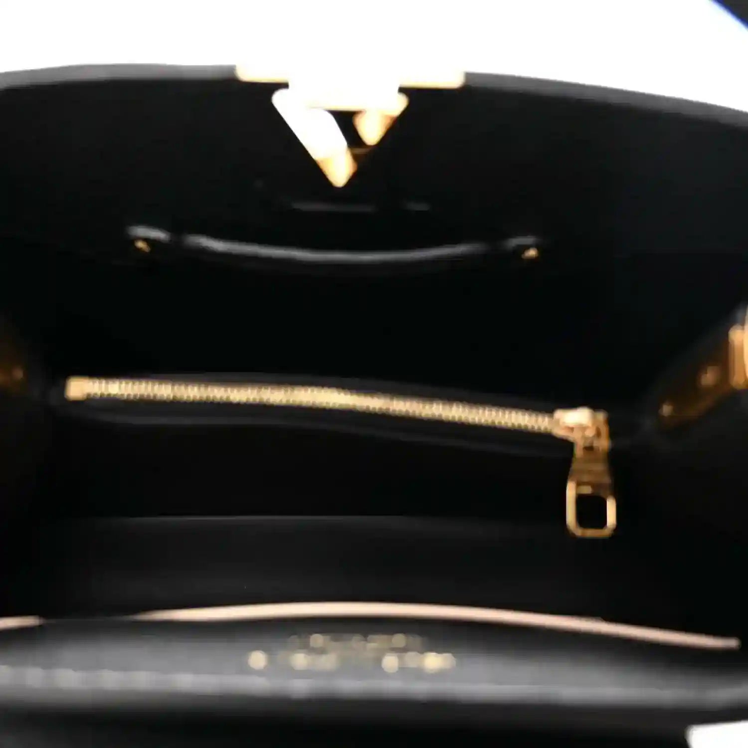 Black leather handbag interior with gold-tone zipper and hardware detail