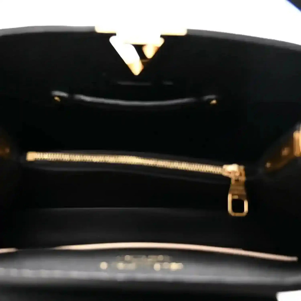 Black leather handbag interior with gold-tone zipper and hardware detail