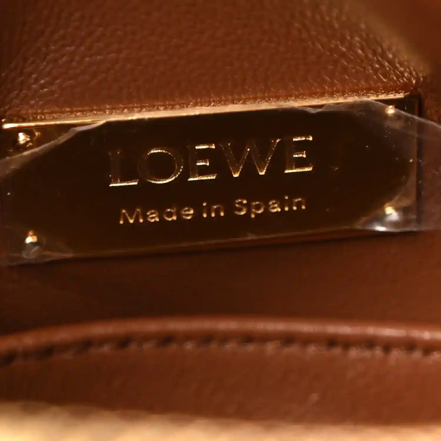 Loewe leather bag tag reading Made in Spain, gold hardware close-up