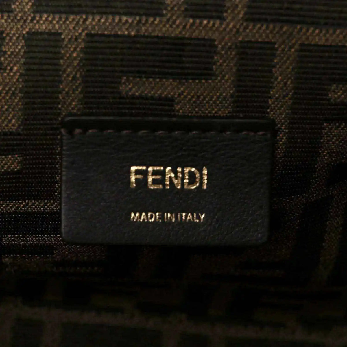 Fendi fabric label on interior of woven leather clutch bag