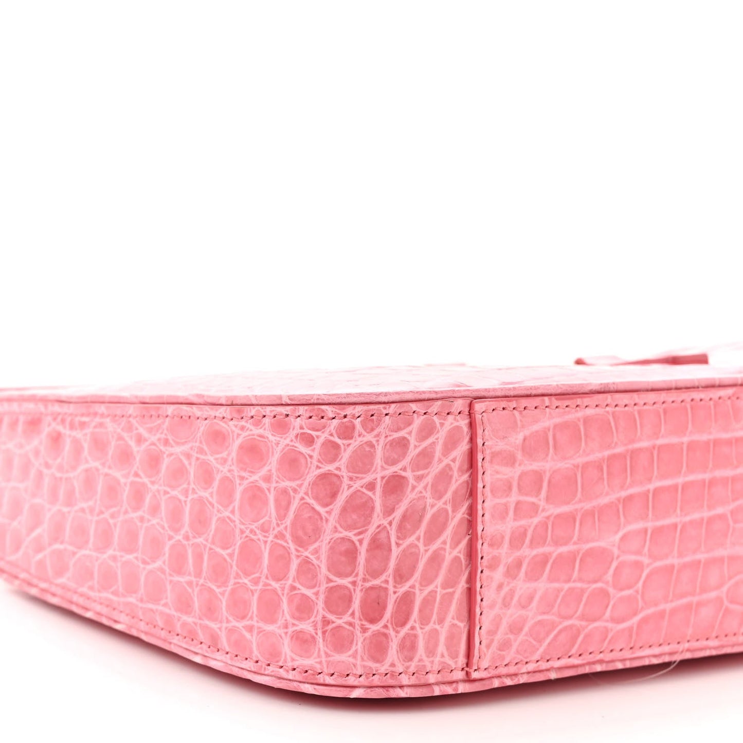 Pink alligator-textured hobo bag side profile with structured shape and top seam