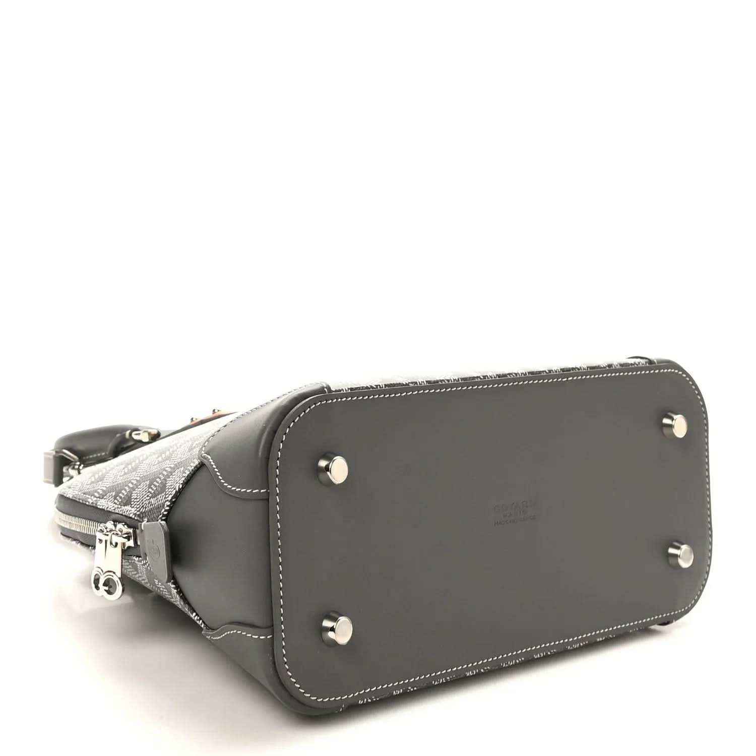 Grey handbag with leather bottom panel, silver studs, and side zipper hardware.