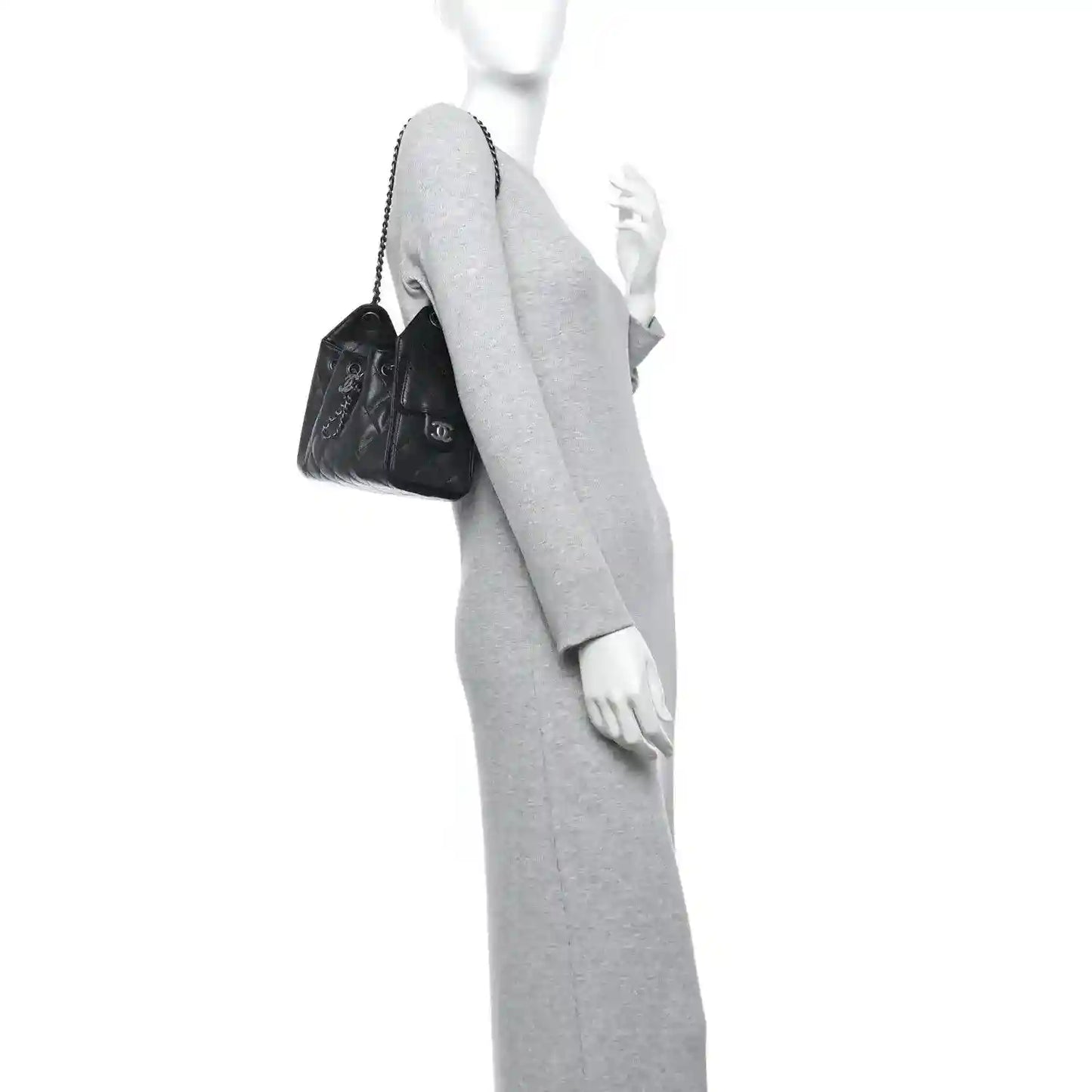 Black quilted mini shoulder bag with chain strap, worn crossbody on model.