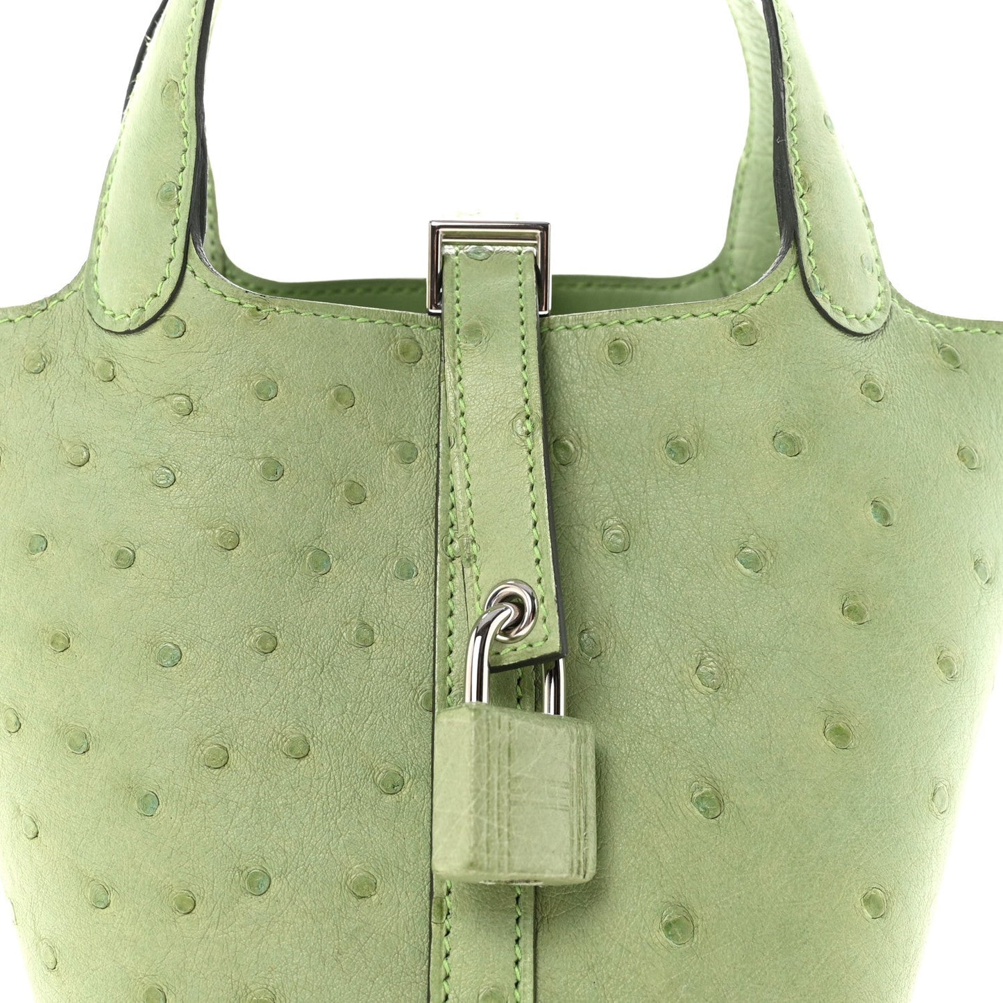 Green ostrich-embossed mini handbag with central lock and stitched handle tabs