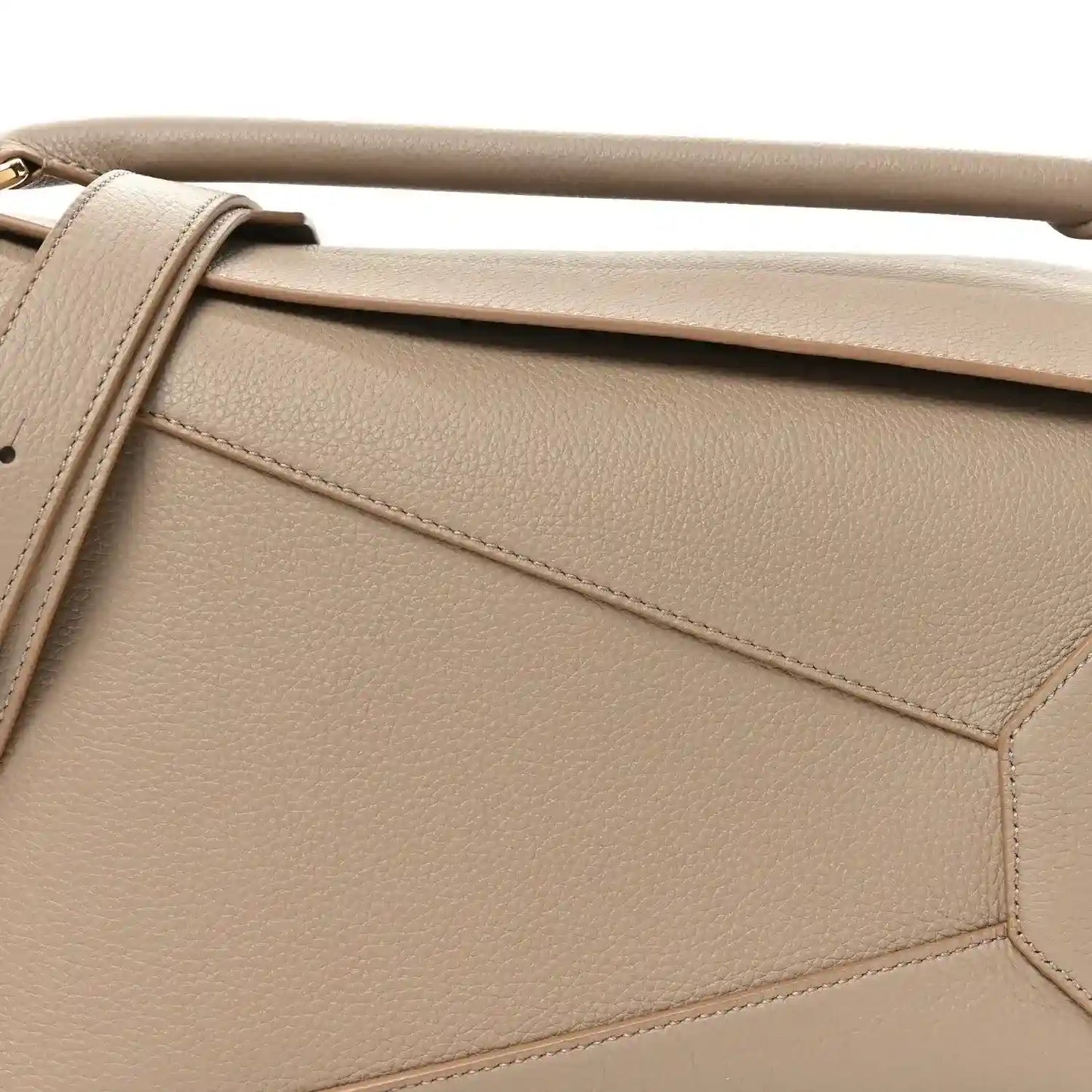 Sand leather bag front panel with diagonal seam detailing and gold-tone edge hardware.