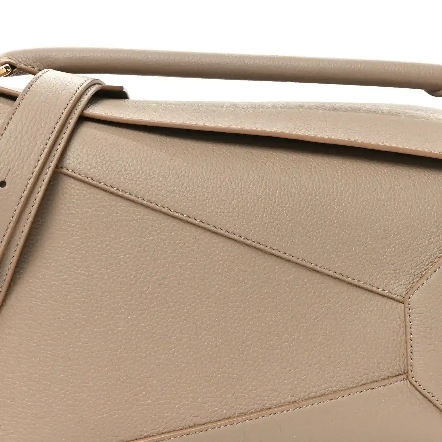 Sand leather bag front panel with diagonal seam detailing and gold-tone edge hardware.