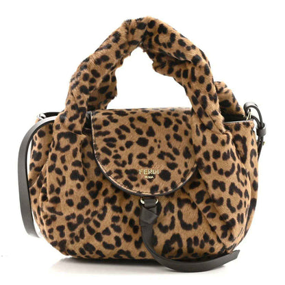 Leopard-print mini spy bag with top handle, curved flap, and black shoulder strap.