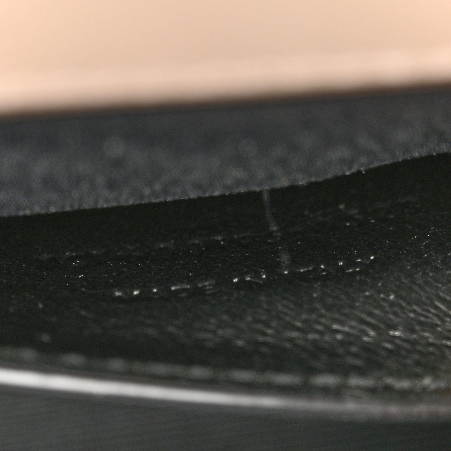 Textured satchel lining seam and fabric grain, dark finish