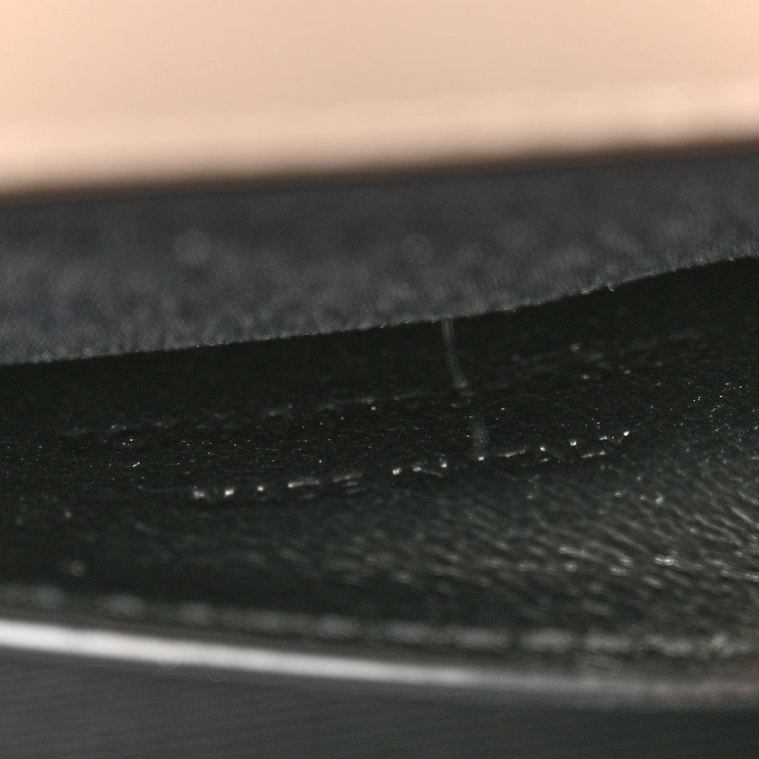 Textured satchel lining seam and fabric grain, dark finish